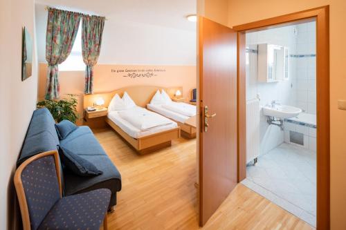 a hotel room with a bed and a bathroom at Pension Zum lustigen Steirer in Bruck an der Mur
