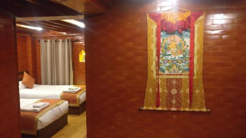 a room with two beds and a mural on a brick wall at Temple House in Kathmandu