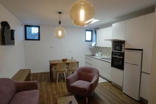 una cucina con divano, sedia e tavolo di Modern house - air cond, free parking, breakfast, by Porto with Love LDA a Vila Nova de Gaia