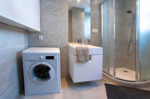 een badkamer met een wasmachine en een wastafel bij Senatorska Apartment in Warschau