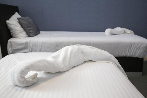 two beds with white towels on top of them at Hotel Flipper Amsterdam in Amsterdam