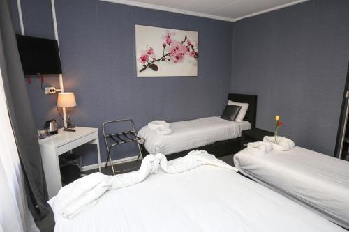 a hospital room with two beds and a desk at Hotel Flipper Amsterdam in Amsterdam
