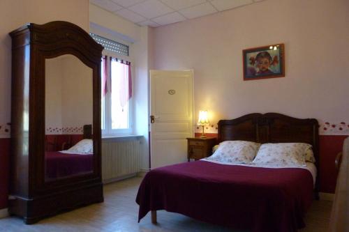 ein Schlafzimmer mit einem Bett und einem großen Spiegel in der Unterkunft Domaine du Vern in Saint-Affrique