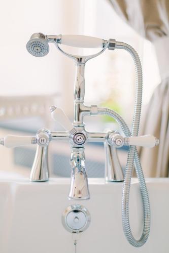 a chrome bathroom sink with a shower head at Chateau d'Urspelt in Urspelt
