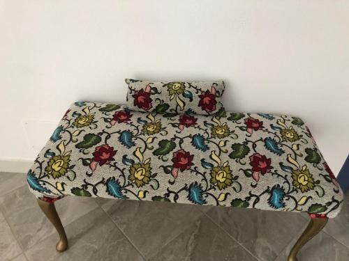 a bed with a flower pattern on it with a pillow at Doci Seven Hotel in Velipojë
