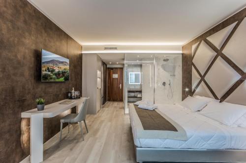 a bedroom with a bed and a desk and a bathroom at Hotel Victoria in Vicenza