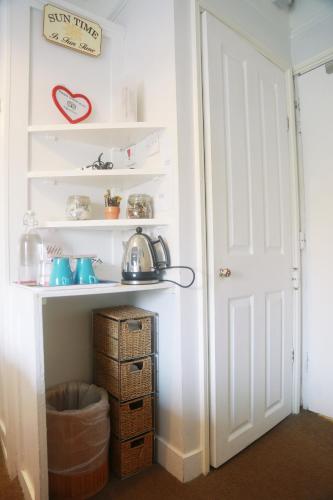 a white pantry with a door and a basket at Motel Schmotel in Brighton & Hove