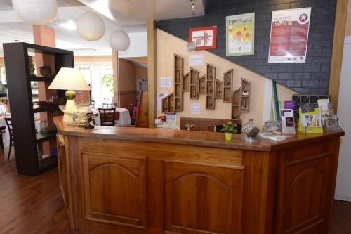 a large wooden counter in a room at The Originals City, Hôtel Le Cheval Rouge, Tours Ouest (Inter-Hotel) in Villandry