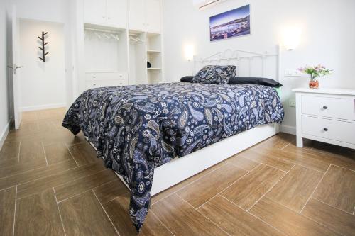 een slaapkamer met een bed met een zwart-wit dekbed bij Palacios 6, nuevo, playa, barrio tranquilo, todos los servicios, PA in Málaga