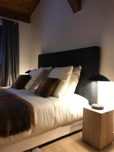 a bedroom with a large bed with white sheets and pillows at La Résidence de L'Ours in Megève