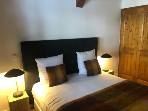 a bedroom with a large bed with two lamps at La Résidence de L'Ours in Megève