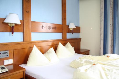una camera d'albergo con due letti con cuscini bianchi di Vitalhotel Sonnblick a Egg am Faaker See