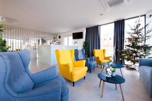 a living room with blue and yellow furniture and a christmas tree at Hotel Tau in Međugorje