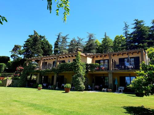 une grande maison avec une pelouse devant elle dans l'établissement Residence Villa Elena, à Guardistallo