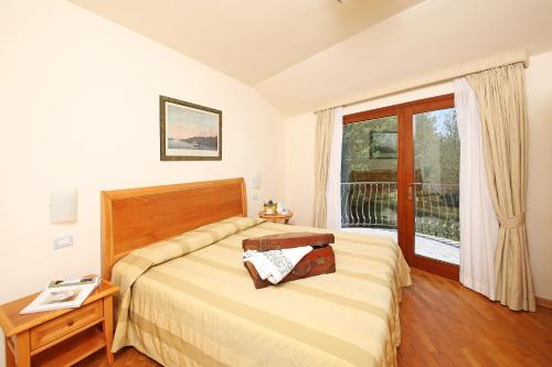 a bedroom with a bed and a table and a window at Appartamenti Borgo in Gardone Riviera