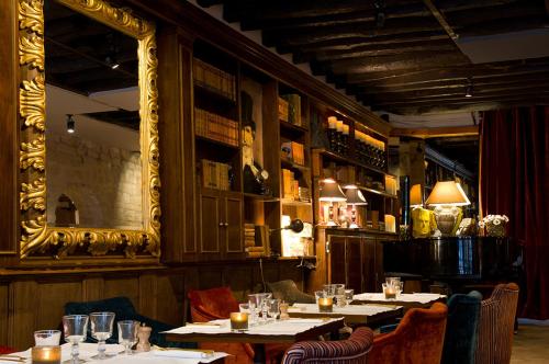 un restaurant avec des tables, des chaises et un miroir dans l'établissement Lafayette Private Apartment, à Paris