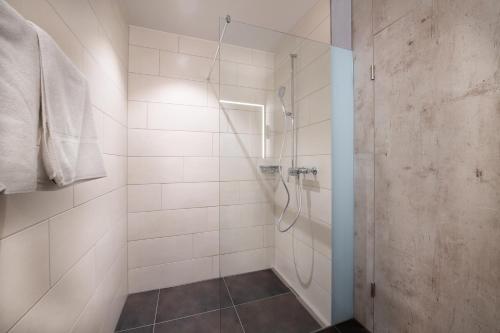 a bathroom with a shower with a glass door at Hotel sleep&stay - Self Check-in in Eglisau