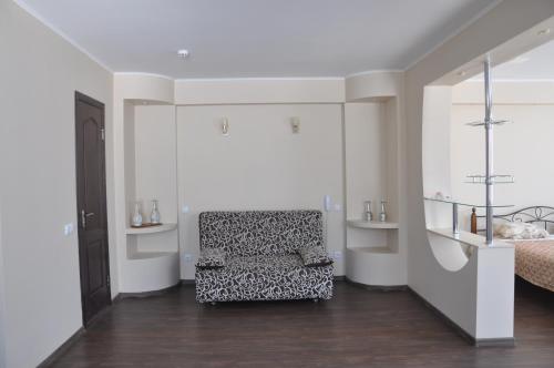 a living room with a chair and a bed at Hotel and Entertaiment Complex Vlada in Cherkasy