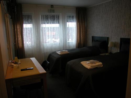 EkshäradにあるCafè Bistro Moccacinoのベッド2台とデスクが備わるホテルルームです。