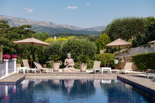 a statue sitting next to a swimming pool at TERRE DE REVE in Le Rouret