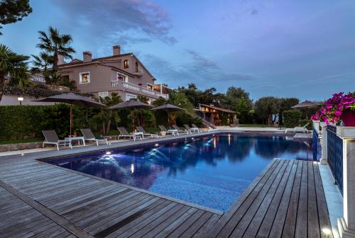 a swimming pool with chairs and a house in the background at TERRE DE REVE in Le Rouret