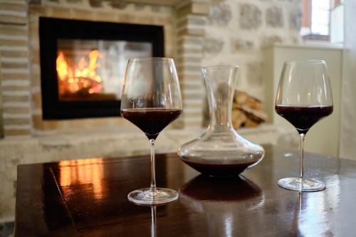 two glasses of wine sitting on a table with a fireplace at Apartments Zebra in Tivat