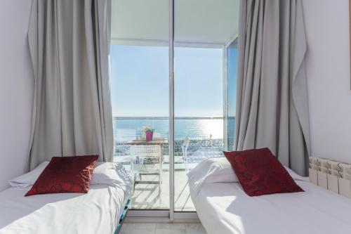 two beds in a room with a view of the ocean at 1410 - Mediterranean Forum Apartment in Barcelona