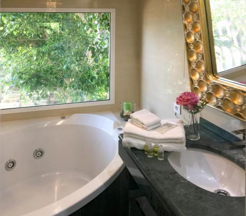 a bathroom with a large tub and a window at Villa de Lujo con Jardines y Piscina in El Puerto de Santa María