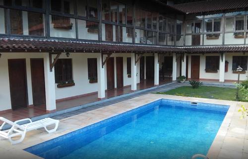 a swimming pool in the courtyard of a building at Pousada Jardim Comary in Teresópolis