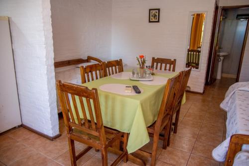 a table with chairs and a yellow table cloth on it at Apart Hotel Manantiales Termal in Termas del Daymán