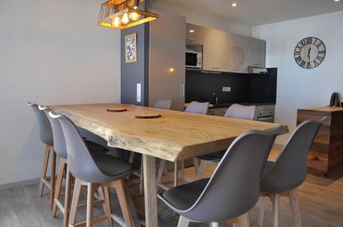 una sala da pranzo con tavolo e sedie in legno di Appt Le Caribou/La Mongie a La Mongie