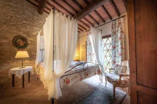 a bedroom with a bed and a window at Le Mascie in Sovicille