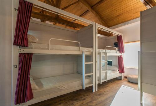 two bunk beds in a room with wooden ceilings at Bercianos1900 in Bercianos del Real Camino