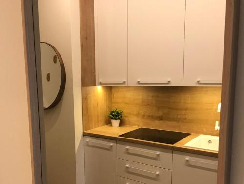 a kitchen with white cabinets and a sink at Elegant apartment in Liepāja