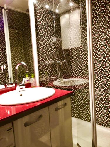une salle de bain avec un lavabo et une douche dans l'établissement Barcaresa-RAVISSANT APPARTEMENT PISCINE VUE MER WIFI PARKING GRATUIT, au Barcarès
