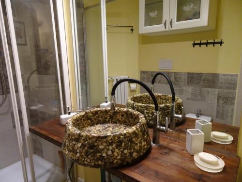 un bagno con due lavandini e due rubinetti di Casa Costa Romantica a Genova