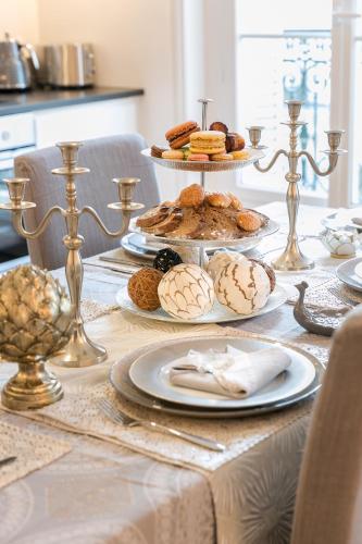 - une table avec des assiettes de pâtisseries et des biscuits dans l'établissement La Résidence du Sénateur, à Paris