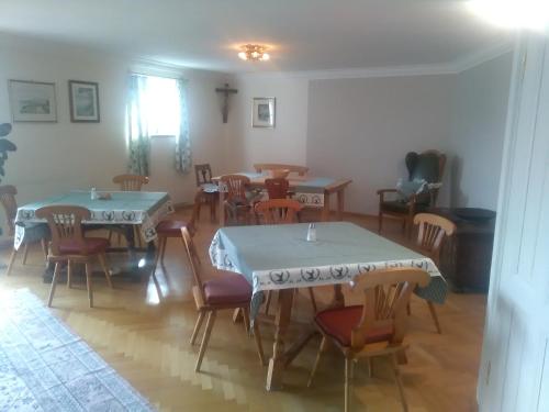 a dining room with two tables and chairs at Attersee Gartenvilla in Nussdorf am Attersee