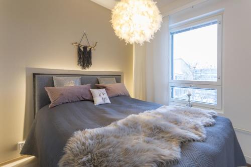 a bedroom with a bed with a furry blanket on it at Tuomas´ luxurious suites, Ahola in Rovaniemi