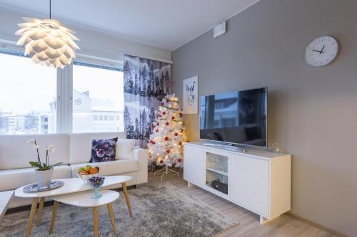 Una sala de estar con un árbol de Navidad y un televisor. en Vasko luxurious suites, Ahola, en Rovaniemi