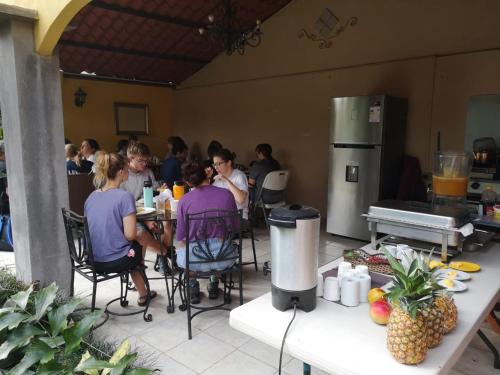 a group of people sitting at tables in a kitchen at Hotel Santa Maria Inn in Alajuela City