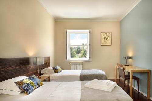 a hotel room with two beds and a window at Casas Da Formiga - Riverview Terrace and Pool in Porto