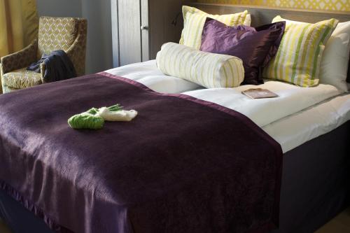 a bed with a purple blanket and a stuffed animal on it at Frogner House - Skovveien in Oslo