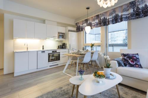 uma cozinha e sala de estar com um sofá e uma mesa em Tuomas´ luxurious suites, Livo em Rovaniemi