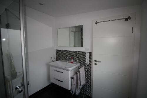 a white bathroom with a sink and a mirror at Ferienwohnung Schamne in Gernsbach
