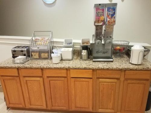 a counter with a coffee maker on top of it at Super 8 by Wyndham Garland Rowlett East Dallas Area in Garland