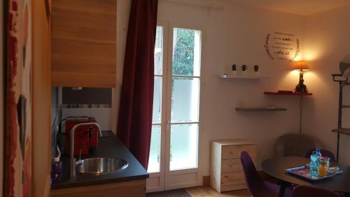 a kitchen with a sink and a table and a window at la source de bougival in Bougival