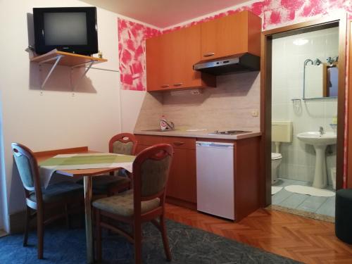 a small kitchen with a table and a sink at Apartmaji Tisa in Moravske Toplice