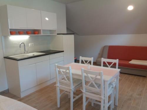 uma cozinha com uma mesa e cadeiras e um sofá em APARTMA BREMEC-STUDIO em Bohinj