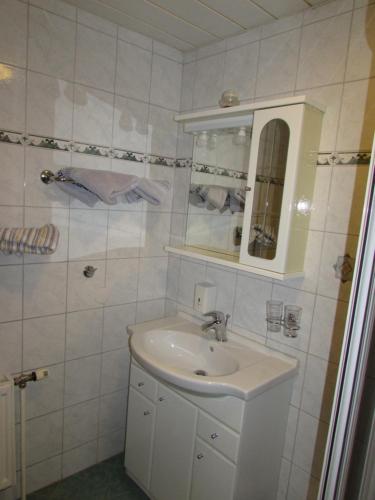 a white bathroom with a sink and a mirror at Arkadenhof Fam. Schneider in Eichenbrunn